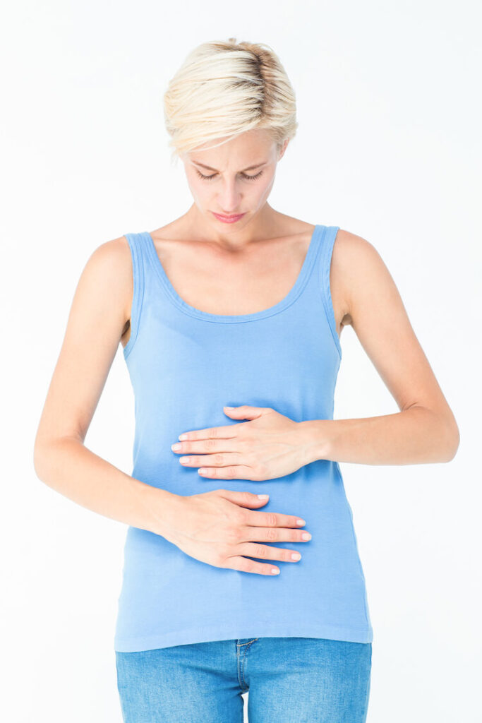 Image shows a woman with her hands on her stomach.