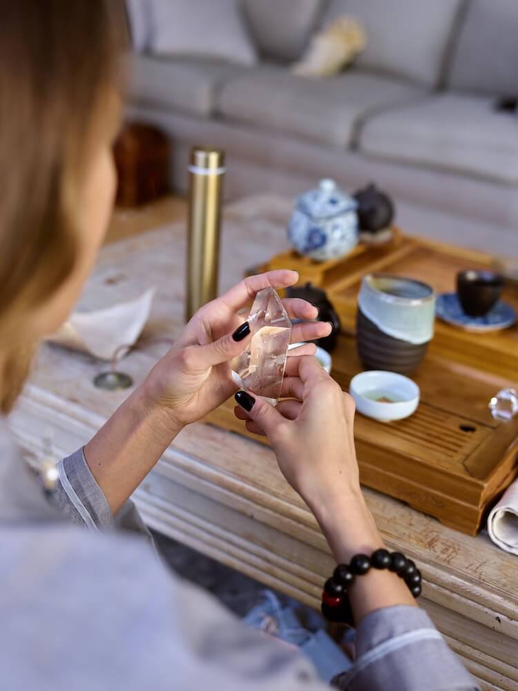 A woman holds a crystal in her hands.