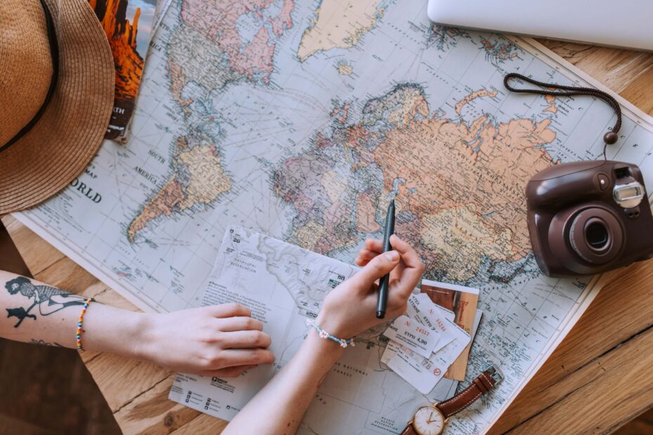 Human Design profile 3/6 Martyr Role Model and 6/3 Role Model Martyr | A woman wearing a hat and holding a pen studies a map of the world.
